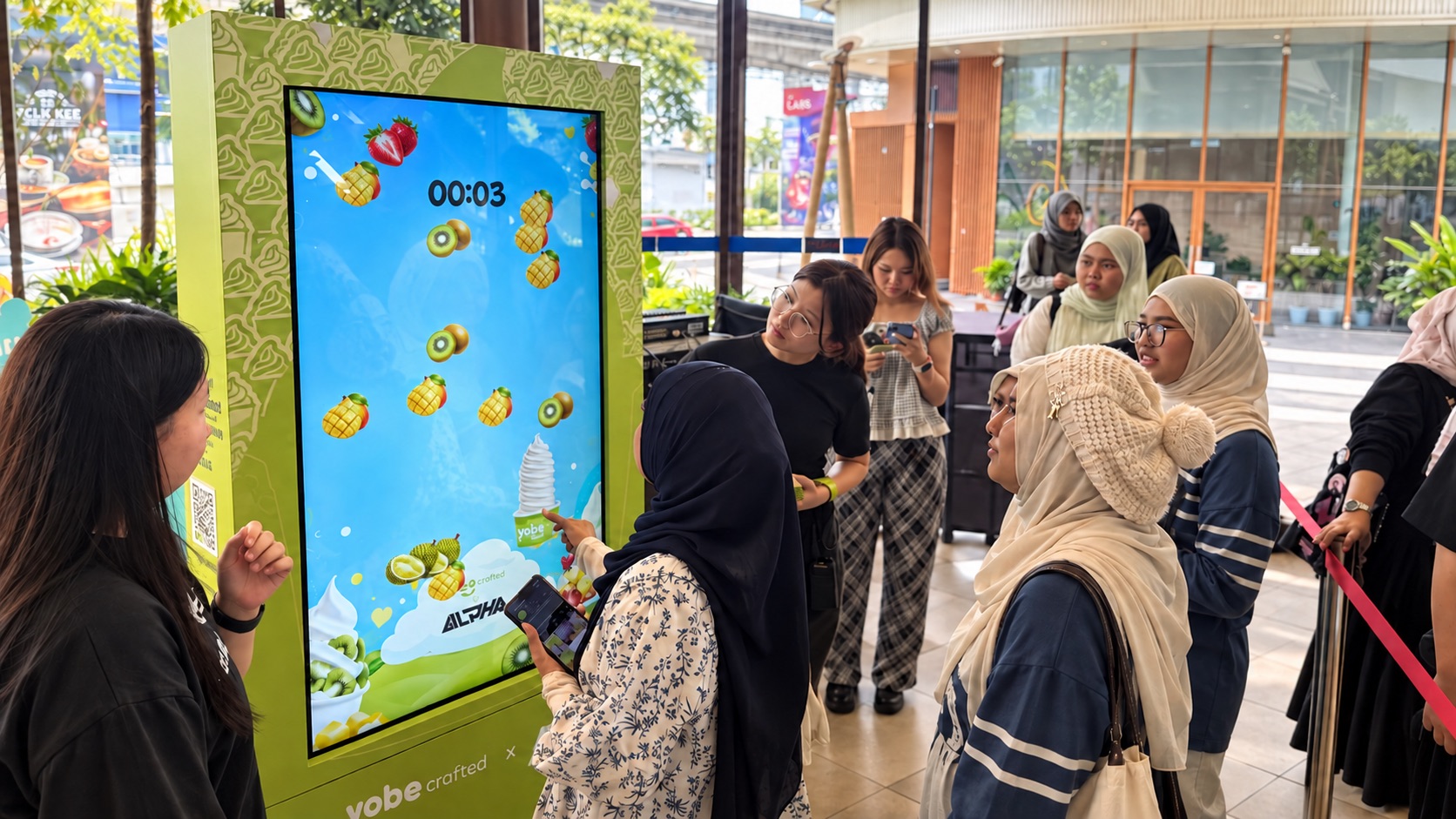 Guests gathered around a branded touchscreen game kiosk at a mall activation